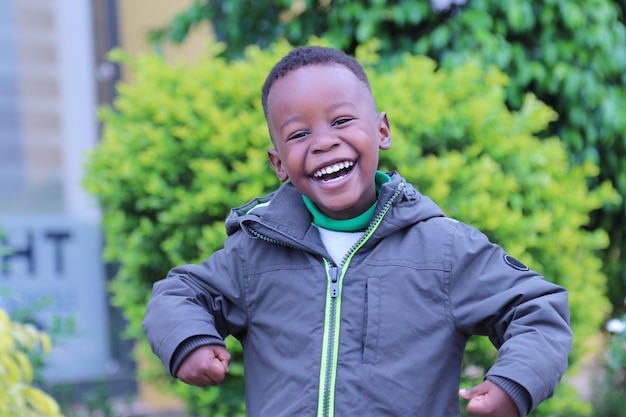 hübscher junger afrikanischer Junge, der lacht und Kamera betrachtet