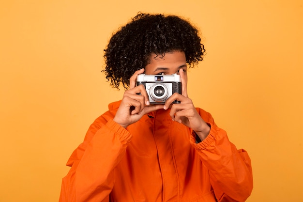 Hübscher junger Afroamerikaner in einem orangefarbenen Regenmantel