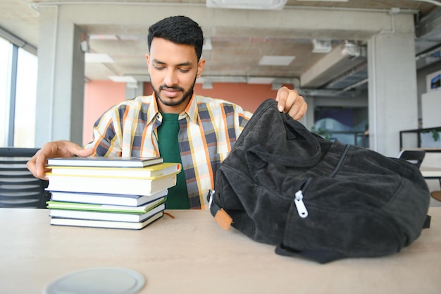 Hübscher junger indischer Junge Student mit Büchern und Rucksack an der Universität Bildungskonzept