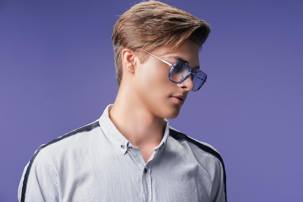 Hübscher junger Kerl in stylischer Brille, während er stylischen Haarschnitt-Modemann wegschaut