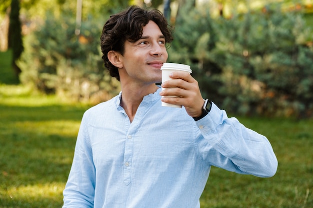 Hübscher junger lässiger Mann, der Kaffee trinkt