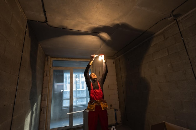 hübscher junger mann, der an der schalttafel der hausbaubaustelle arbeitet.