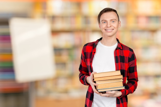 Hübscher junger Mann, der Bücher hält