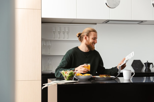 Hübscher junger Mann, der Frühstück hat