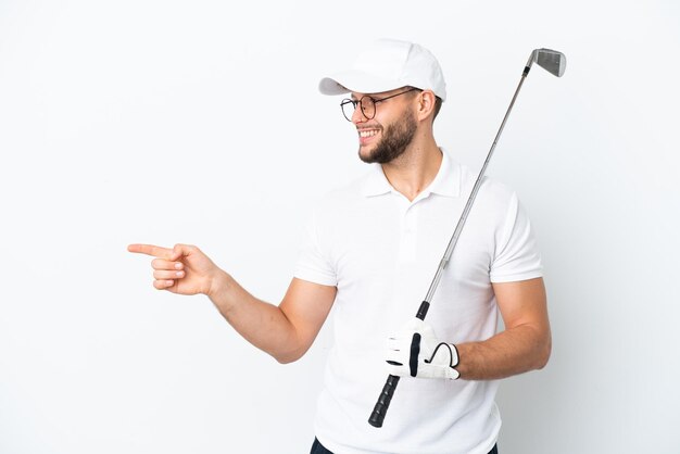 Foto hübscher junger mann, der golf spielt, isoliert auf weißem hintergrund, der mit dem finger zur seite zeigt und ein produkt präsentiert