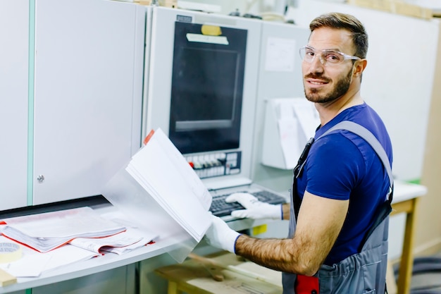 Hübscher junger Mann, der in der Möbelfabrik arbeitet