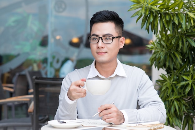 Hübscher junger Mann, der Kaffee in der Stadt trinkt