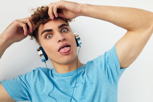 Hübscher junger Mann in blauen T-Shirts Kopfhörer Mode-Lifestyle unverändert