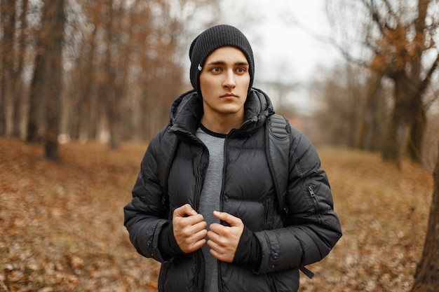 Hübscher junger Mann in der Winterkleidung mit einem Rucksack