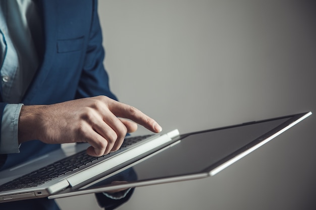 Hübscher junger mann mit laptop auf dunklem hintergrund