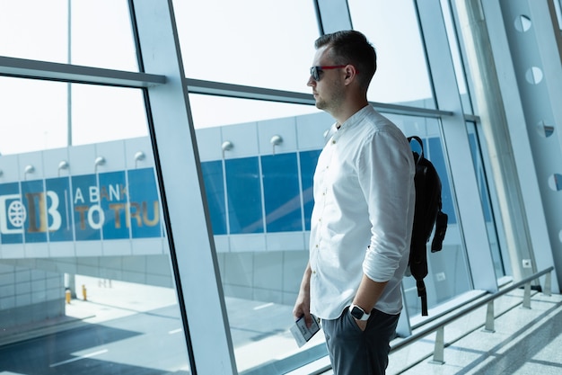 Hübscher junger Mann mit Rucksack am Flughafen