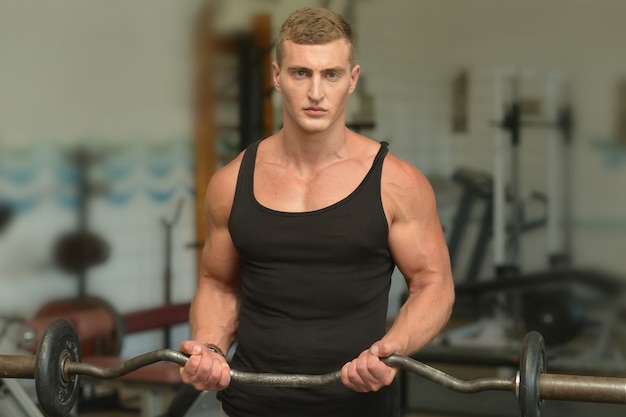 Hübscher junger Mann trainiert in einem Fitnessstudio