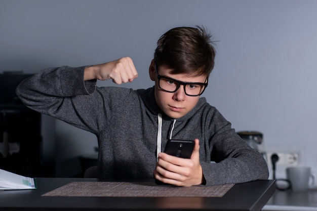 Hübscher junger Mann wütend und wütend mit seinem Handy