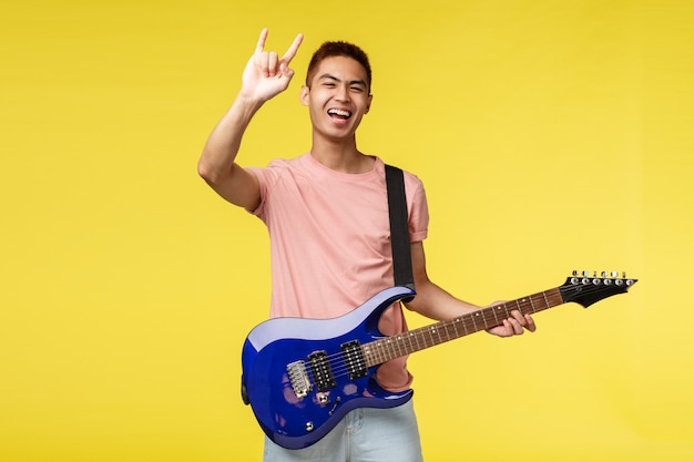 Hübscher junger Musiker, der Gitarre spielt und singt