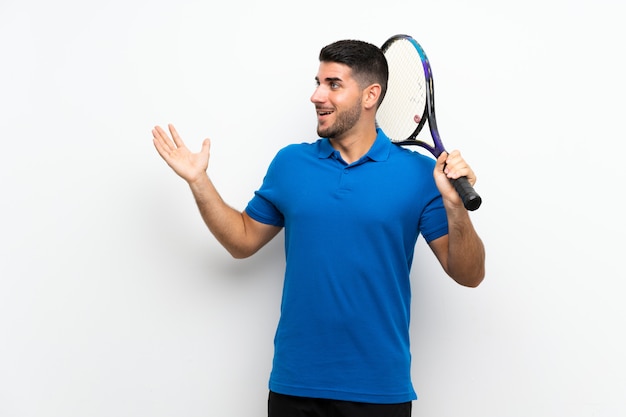Hübscher junger Tennisspielermann über lokalisierter weißer Wand mit Überraschungsgesichtsausdruck