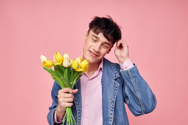 Hübscher Kerl Blumenstrauß aus gelben Blumen Geschenk Urlaub eleganten Stil rosa Hintergrund unverändert