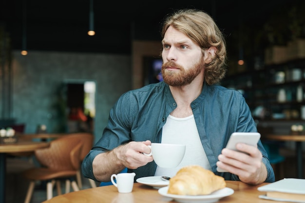 Hübscher Kerl, der Kaffee im Café trinkt