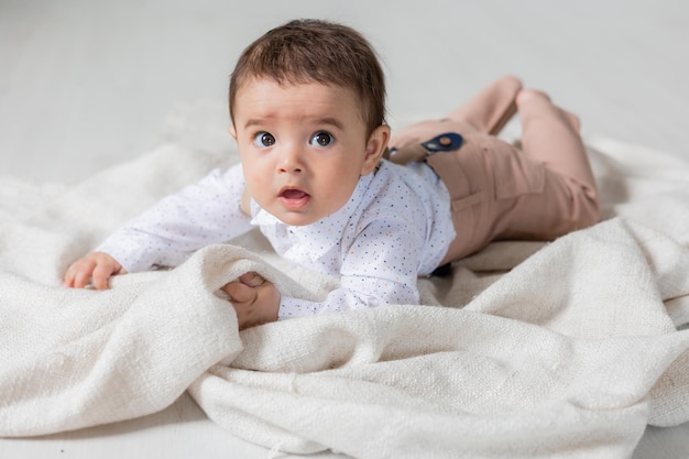 Hübscher kleiner Junge, gekleidet, wie er auf der Gesundheitskarte der Decke liegt