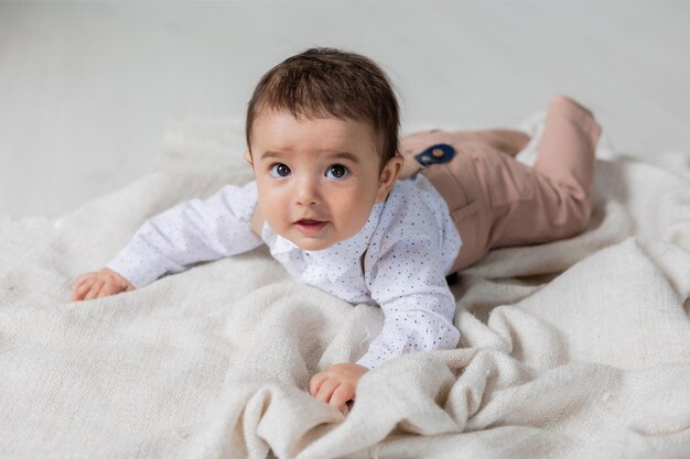 Hübscher kleiner Junge, gekleidet, wie er auf der Gesundheitskarte der Decke liegt