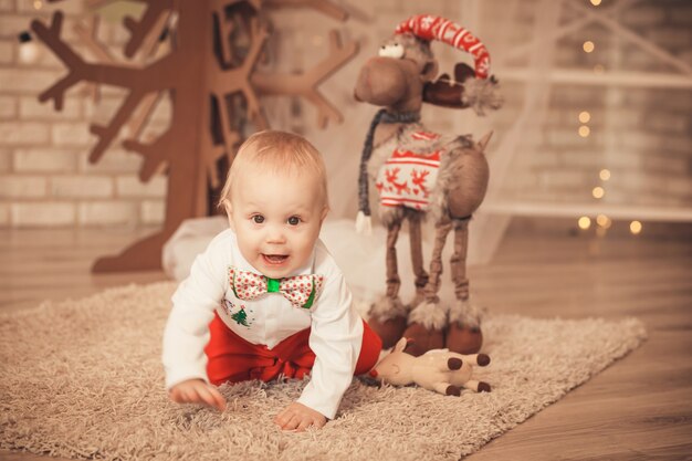 Hübscher kleiner junge unter weihnachtsdekorationen