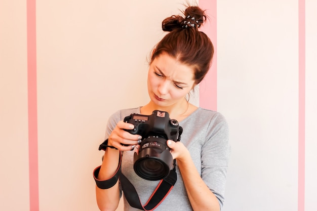 Hübscher Mädchenphotograph untersucht ihre Kamera und macht lustiges d