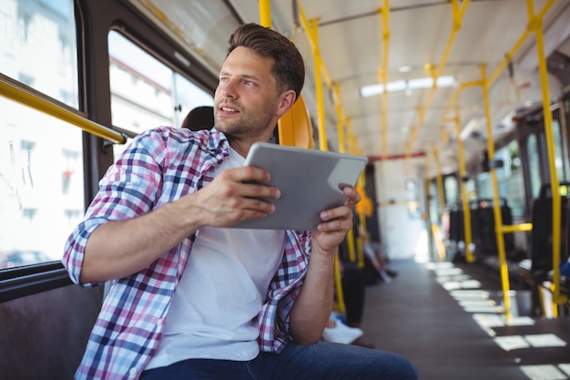 Hübscher Mann, der digitales Tablett verwendet