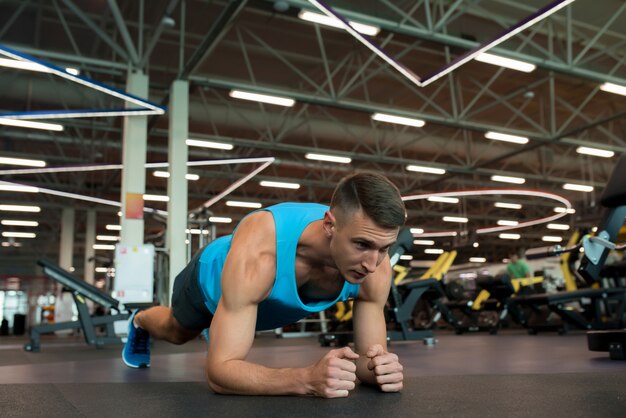 Hübscher Mann, der im Fitnessstudio trainiert