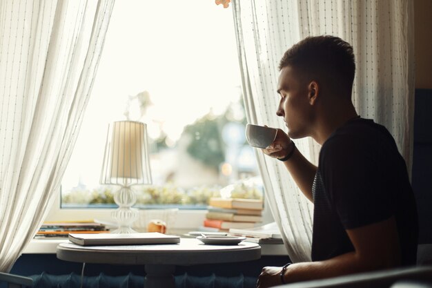 Hübscher Mann, der Kaffee in einem Restaurant trinkt.