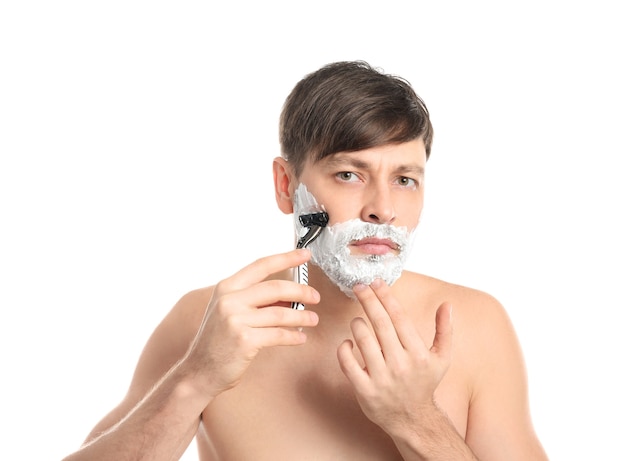 Foto hübscher mann, der sich auf weiß rasiert