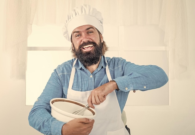 hübscher Mann mit Bart und Schnurrbart Kochen von Essen professioneller Restaurantkoch Backen erfahrener Bäcker verwenden Küchenutensilien zum Kochen männlicher Koch mit Hut bereiten eine gesunde Mahlzeit vor