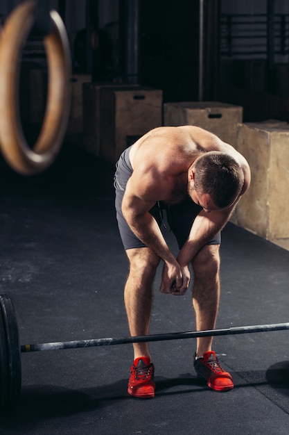 Hübscher Mann müde nach Gewichtheben im Fitnessstudio