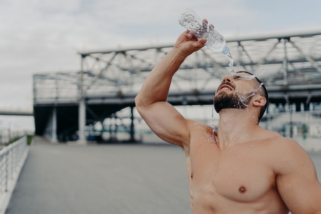 Hübscher muskulöser Mann mit nacktem Oberkörper im Freien, der Fitness-Training tut