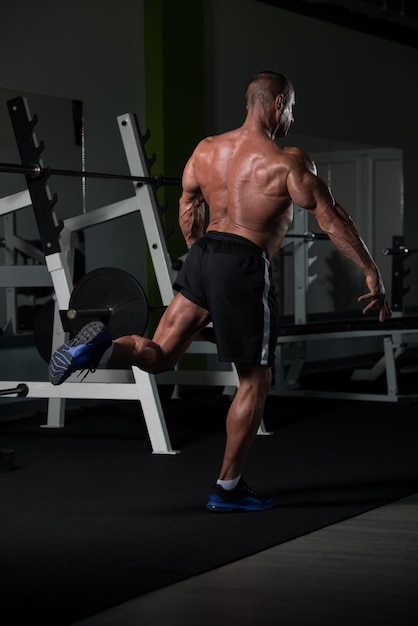 Hübscher reifer Mann, der stark in der Turnhalle steht und Muskeln muskulöser athletischer Bodybuilder-Eignungs-Mann aufwirft, der nach Übungen aufwirft