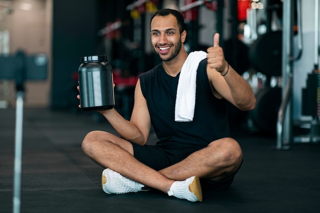 Hübscher schwarzer Fitness-Blogger, der Abonnenten in sozialen Medien Whey-Protein bewirbt