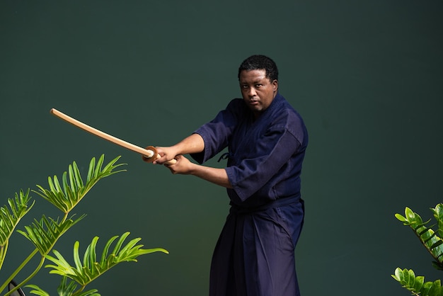 Hübscher schwarzer Kampfkünstler mit Kendo-Kampfkunstkostüm