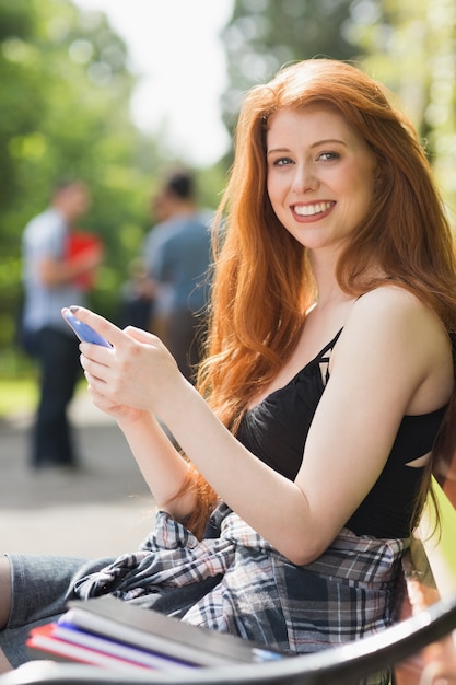 Hübscher Student, der draußen einen Text sendet