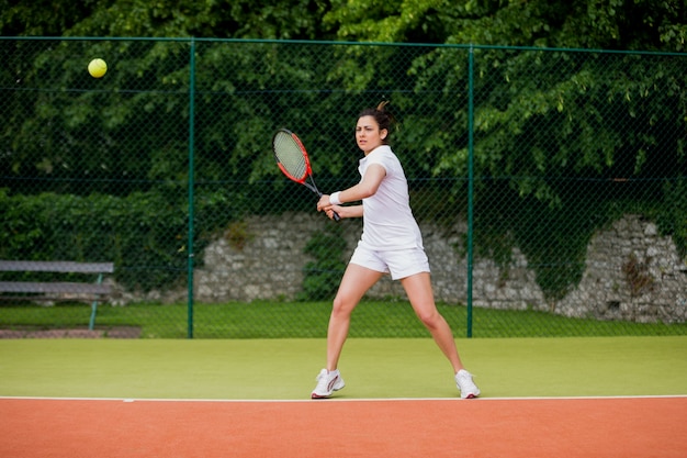 Hübscher Tennisspieler, der ungefähr Ball schlägt