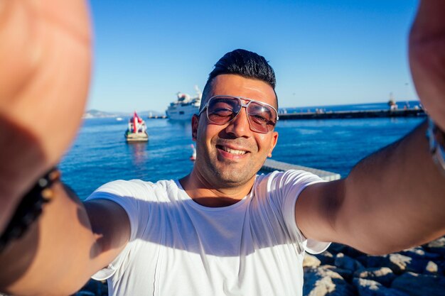 Hübscher türkischer Mann, der Selfie-Fotoporträt auf Kamera-Smartphone am Strand der Türkei macht.