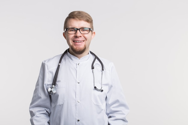 Hübscher weißer Doktormann in der Brille und im weißen medizinischen Kleid