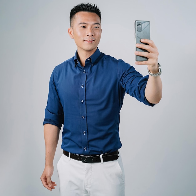 Hübsches asiatisches Geschäftsmannhemd Videoanrufe lokalisierte graue Wand