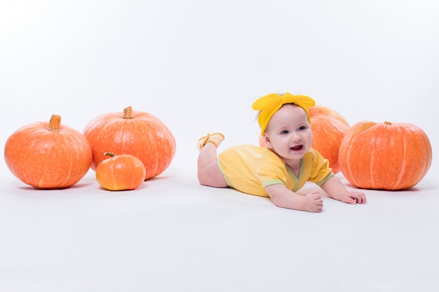 Hübsches Baby in einem gelben Körper mit einem gelben Bogen auf ihrem Kopf