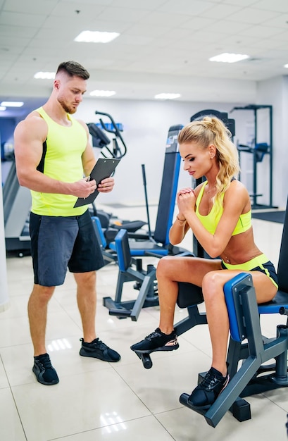 Hübsches Frauentraining mit Trainer im Fitnessstudio Athletisches Lifestyle-Training mit Trainer