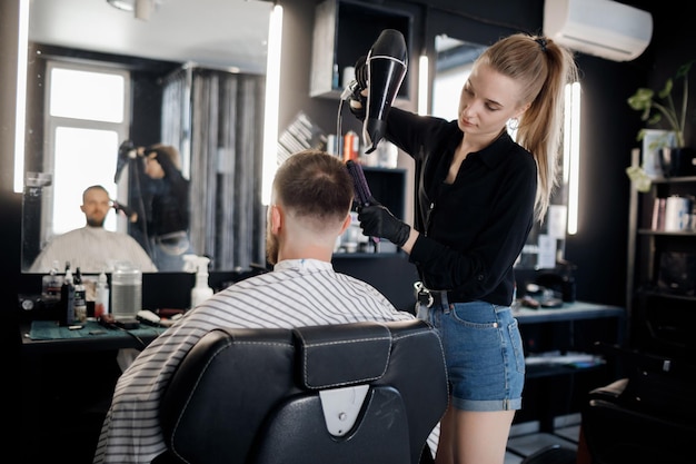 hübsches friseurmädchen, das haare schneidet