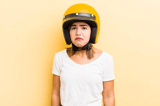 Hübsches hispanisches Mädchen, das sich traurig und weinerlich fühlt, mit einem unglücklichen Blick und einem weinenden Motorradkonzept