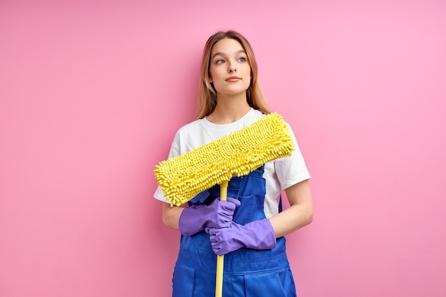 Hübsches junges kaukasisches Mädchen, das Boden mit Mopp säubert