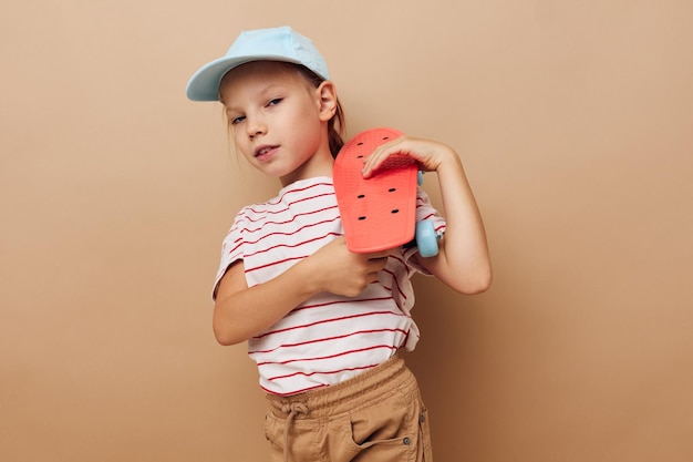 Hübsches junges Mädchen mit einem Children39s-Skateboard in der Hand lächelt isolierten Hintergrund