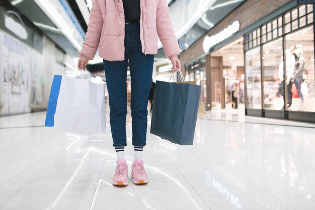 Hübsches junges Mädchen mit einer rosa Jacke im Einkaufszentrum