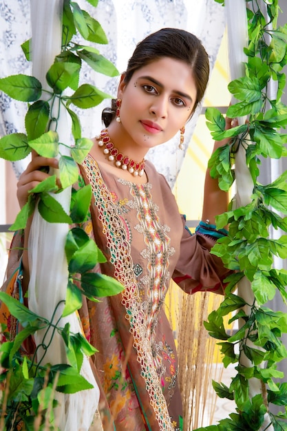 Hübsches junges Model-Portrait, das mit Pflanzenbügeln für traditionelles Fotoshooting posiert