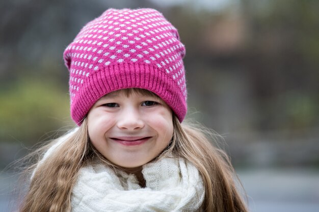 Hübsches Kindermädchen in der warmen gestrickten Winterkleidung draußen.