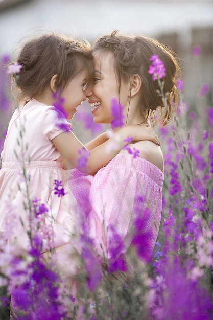 Hübsches kleines Mädchen und ihre Mutter mit Blumen. Familie im Freien